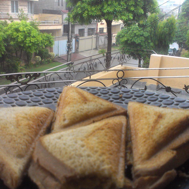 Toasted aaloo qeema sandwiches on a grill, photographed on a rainy afternoon